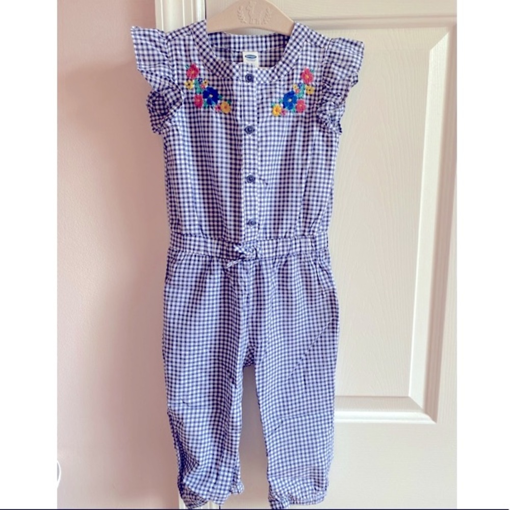 Adorable flutter sleeved blue and white checkered romper with floral embroidery.